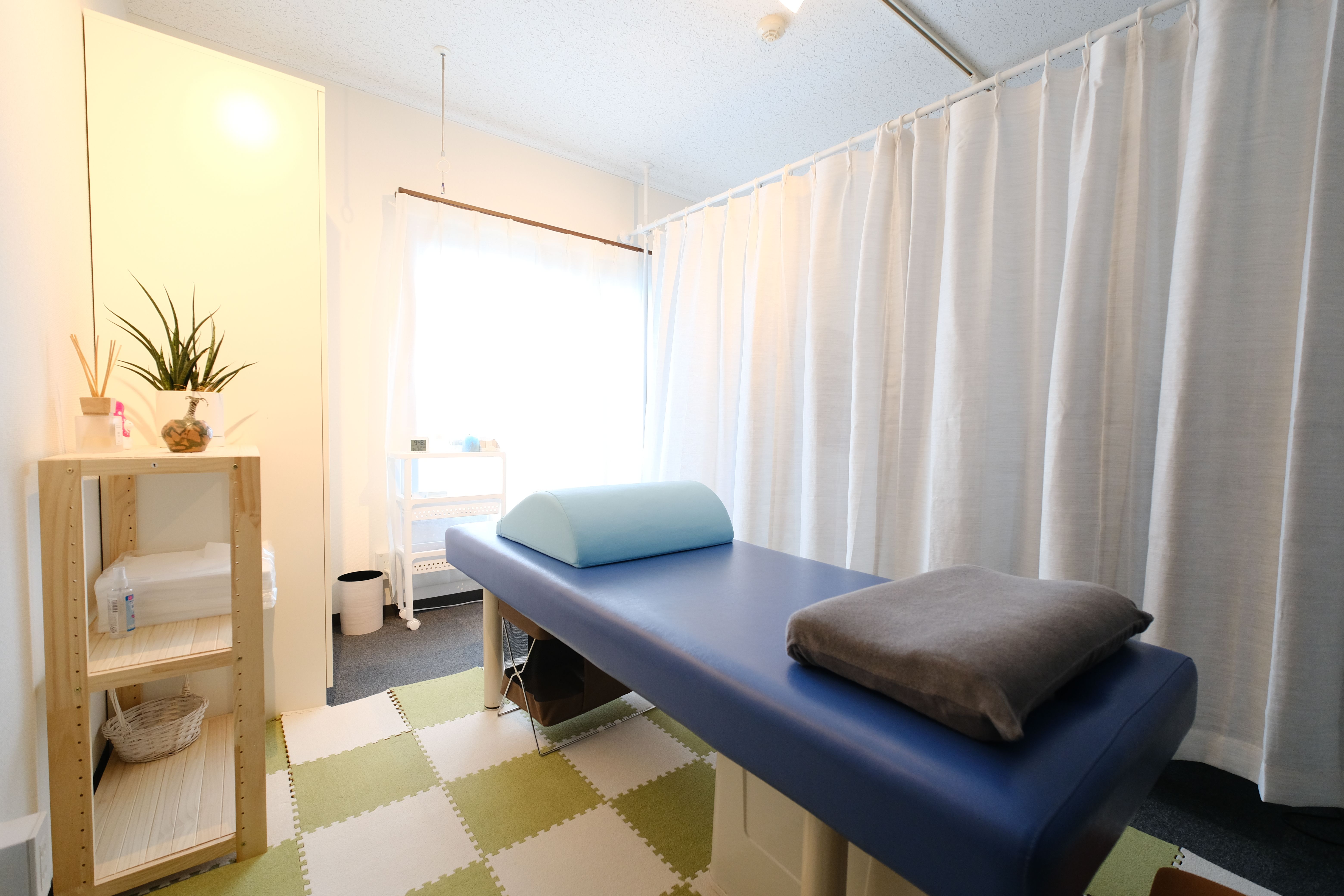 院内の雰囲気（施術ベッドとカーテン）